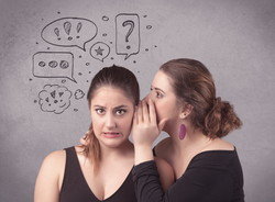 スペインで吹き出しを出しながらささやき合う 2 人の女性。