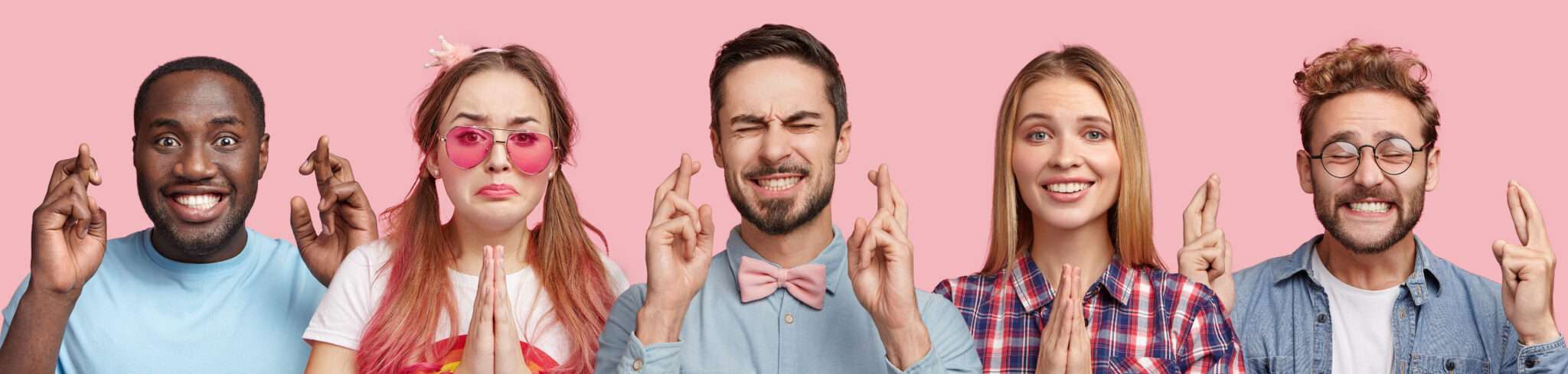 ピンクの背景にスペインの服装で十字のサインをする人々のグループ。