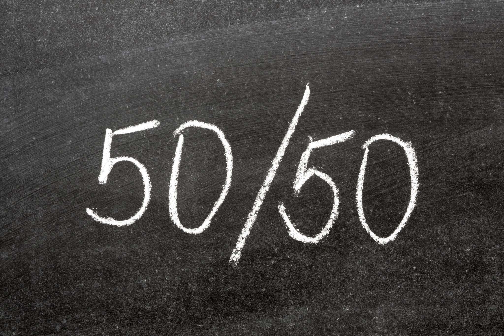 黒板に白いチョークで書かれた「50/50」という文字がスペインに囲まれています。