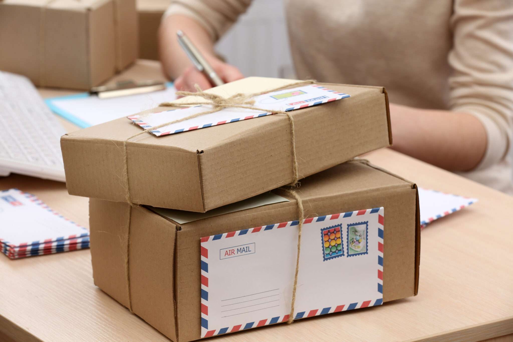 スペインから届いた郵便ポストを積んだ机に座る女性。
