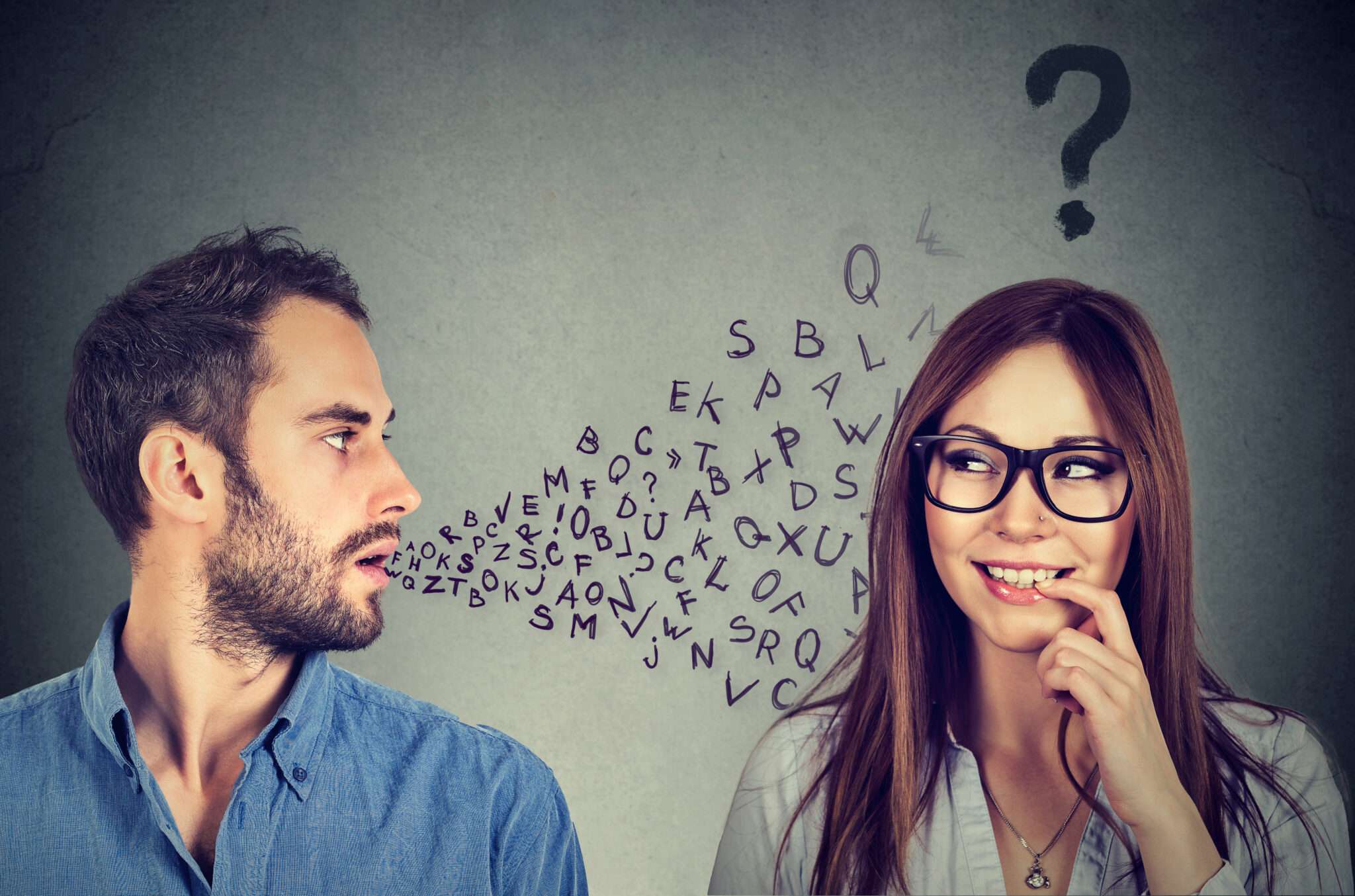 スペインの疑問符の前で会話する男性と女性。
