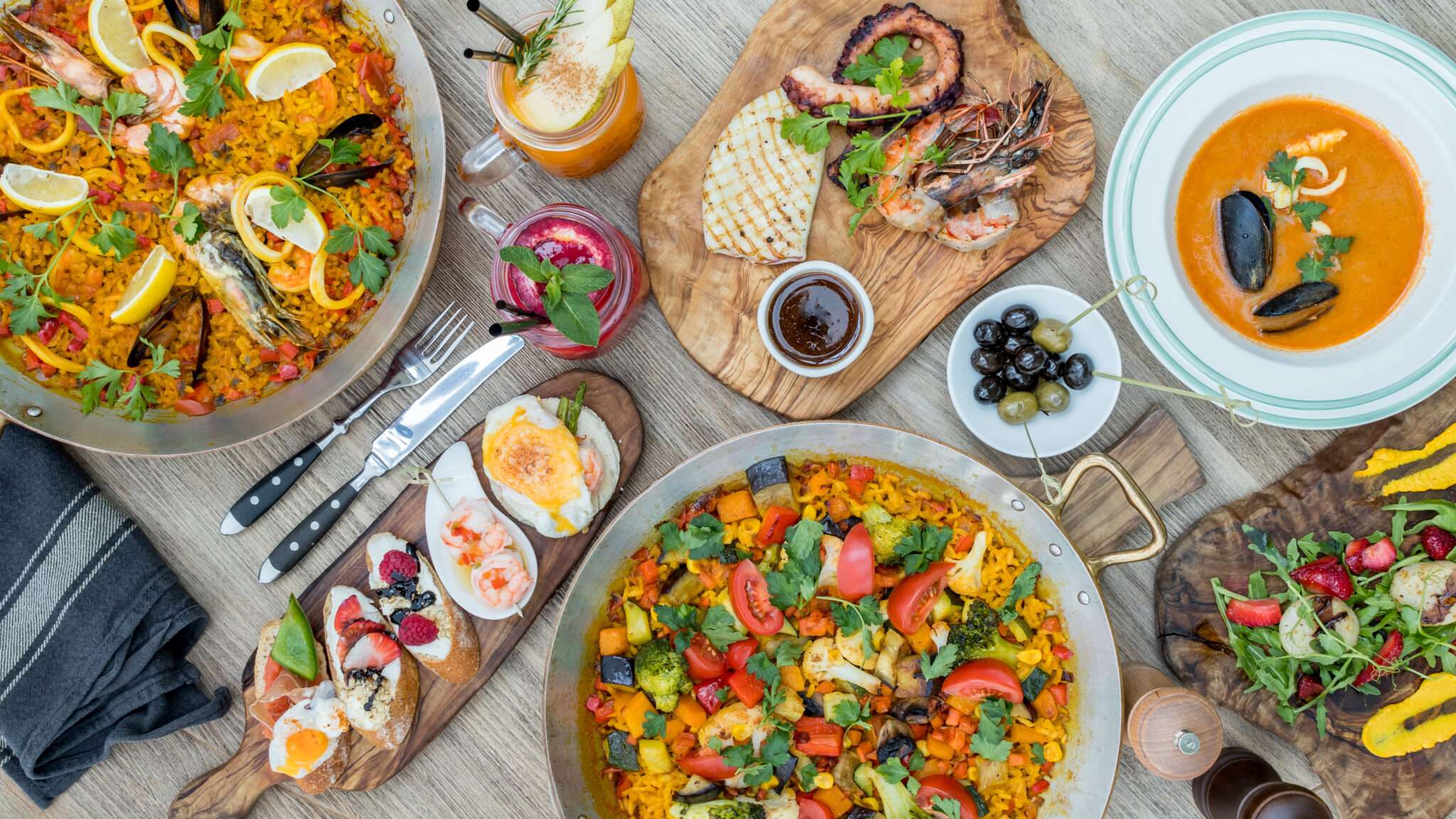 スペイン風の要素で装飾された木製のテーブルに食べ物がいっぱいのテーブル。