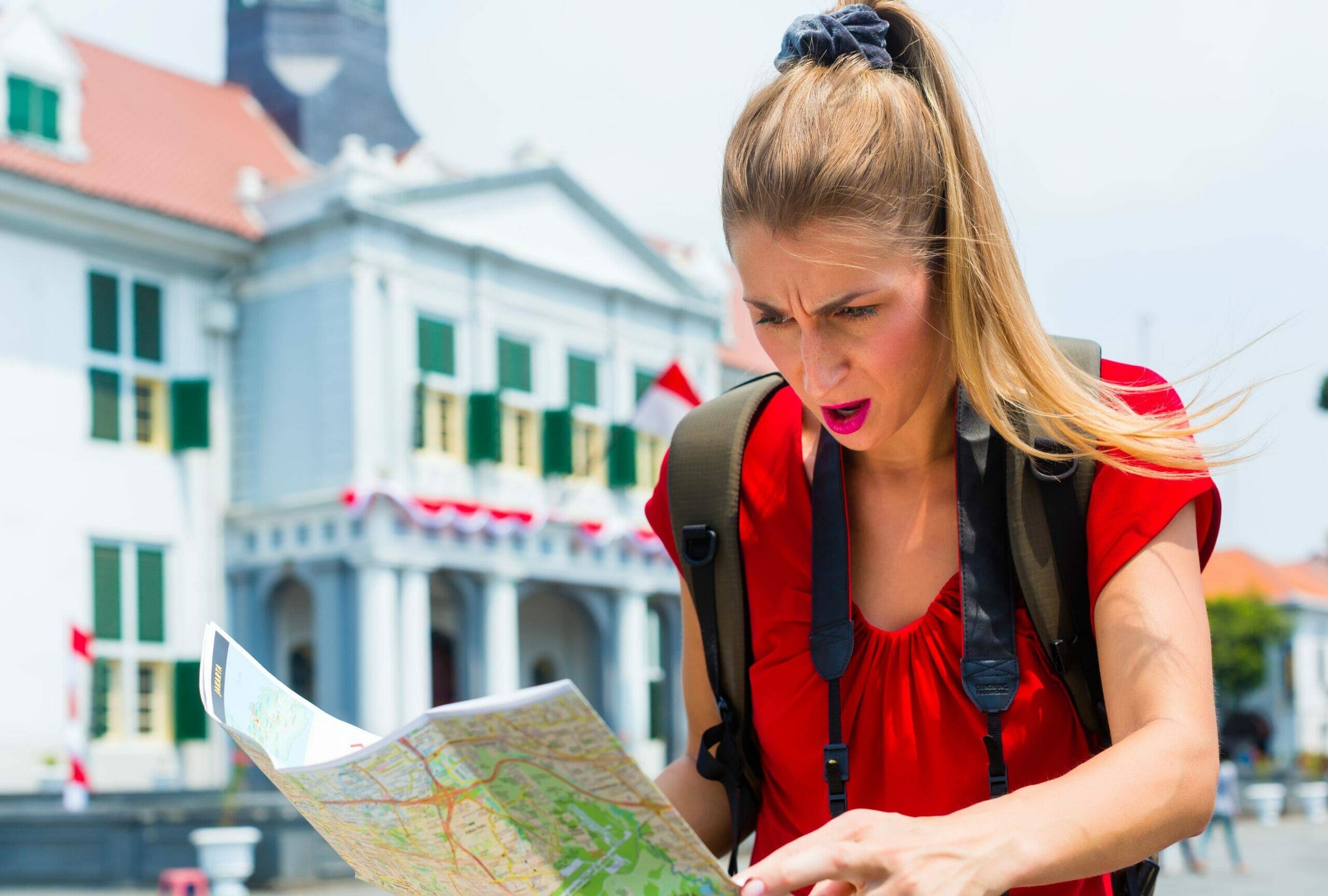 スペインの建物の前で地図を見ている女性。