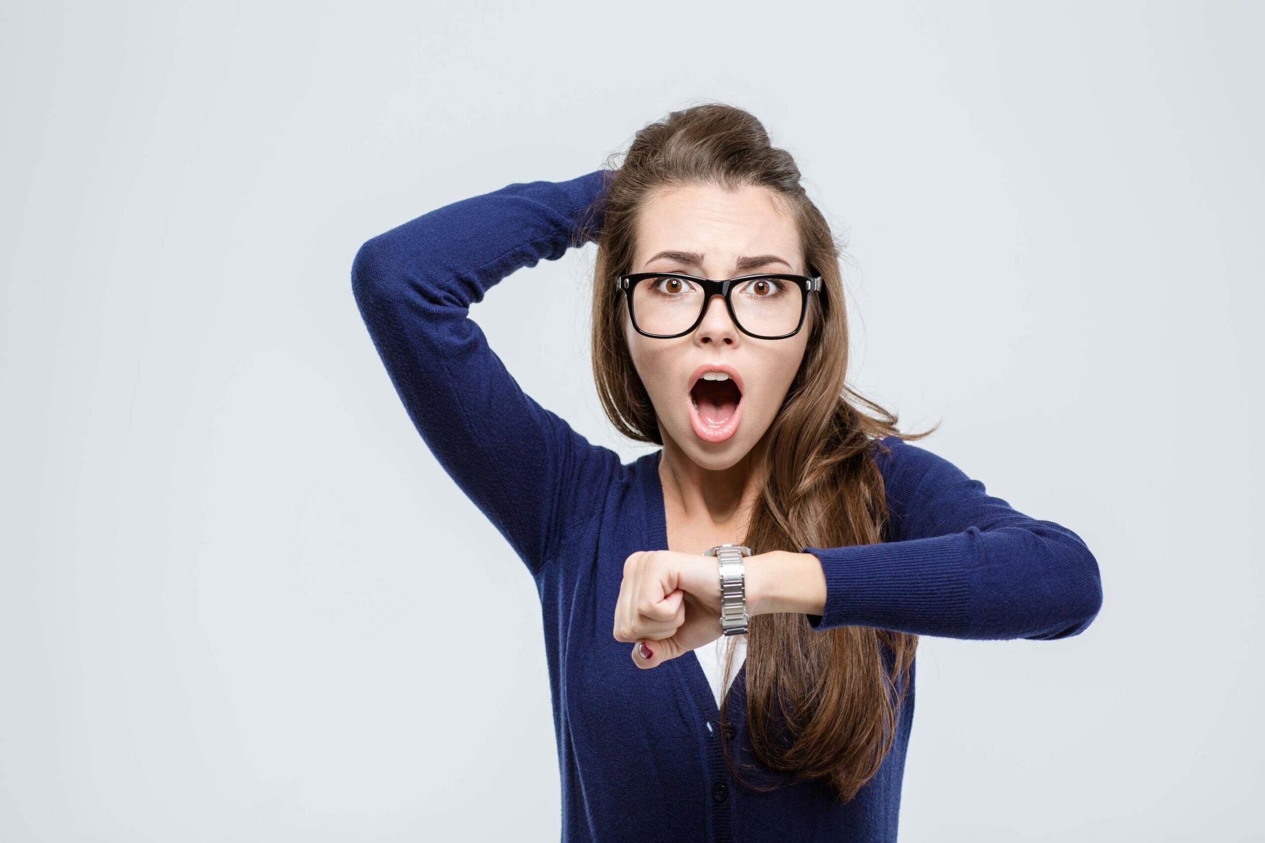 スペインで時計を指差す眼鏡をかけた若い女性。