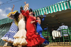 テントの前で踊るスペイン風のドレスを着た女性のグループ。