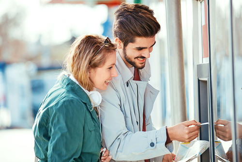 スペイン出身の男性と女性が ATM を見ています。
