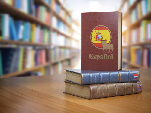 説明: 本のスペイン国旗が本棚の前のテーブルに置かれています。
