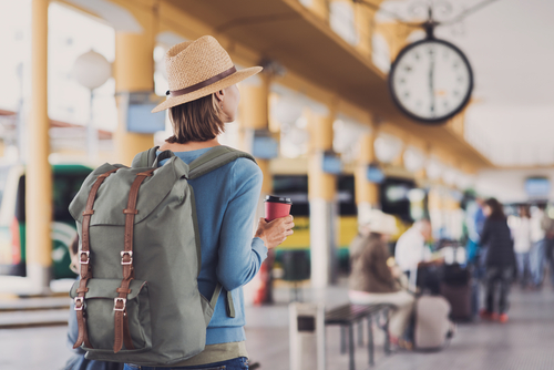 バックパックを背負ってスペインの駅に立つ女性。