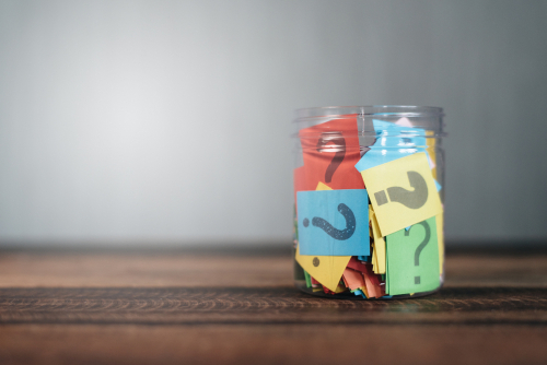 スペインの木製テーブルの上に置かれた疑問符でいっぱいの瓶。
