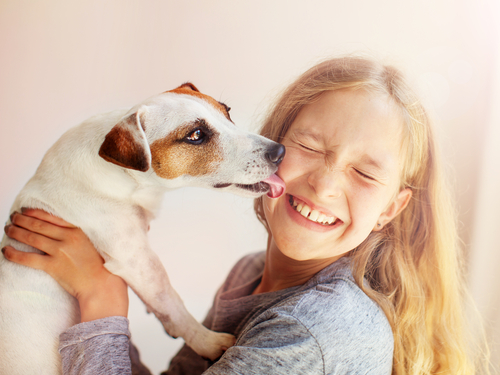 スペインの女の子が犬を抱いています。