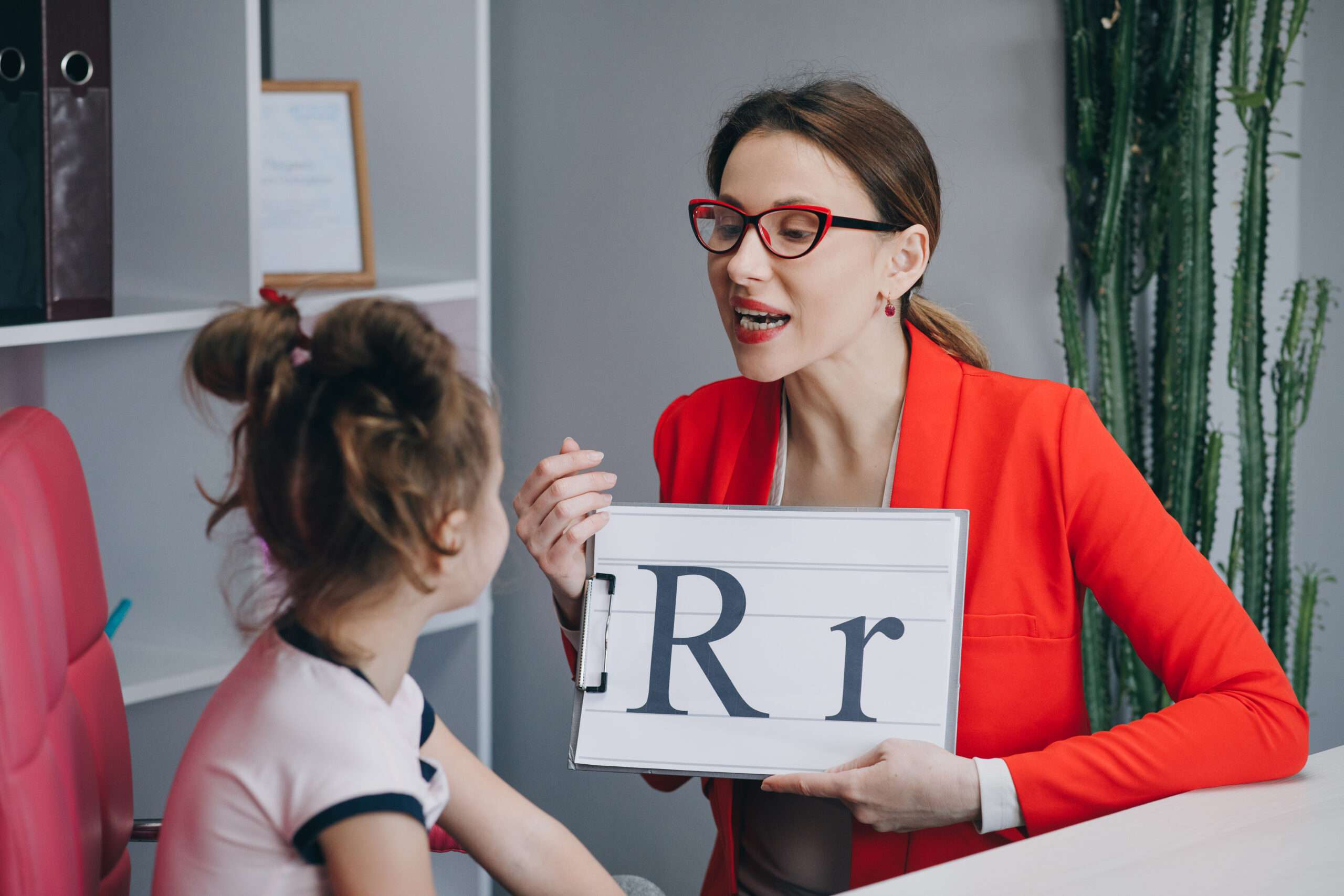 スペイン語の「rr」と「l」の発音の違いをサインを持ってデモする女性。