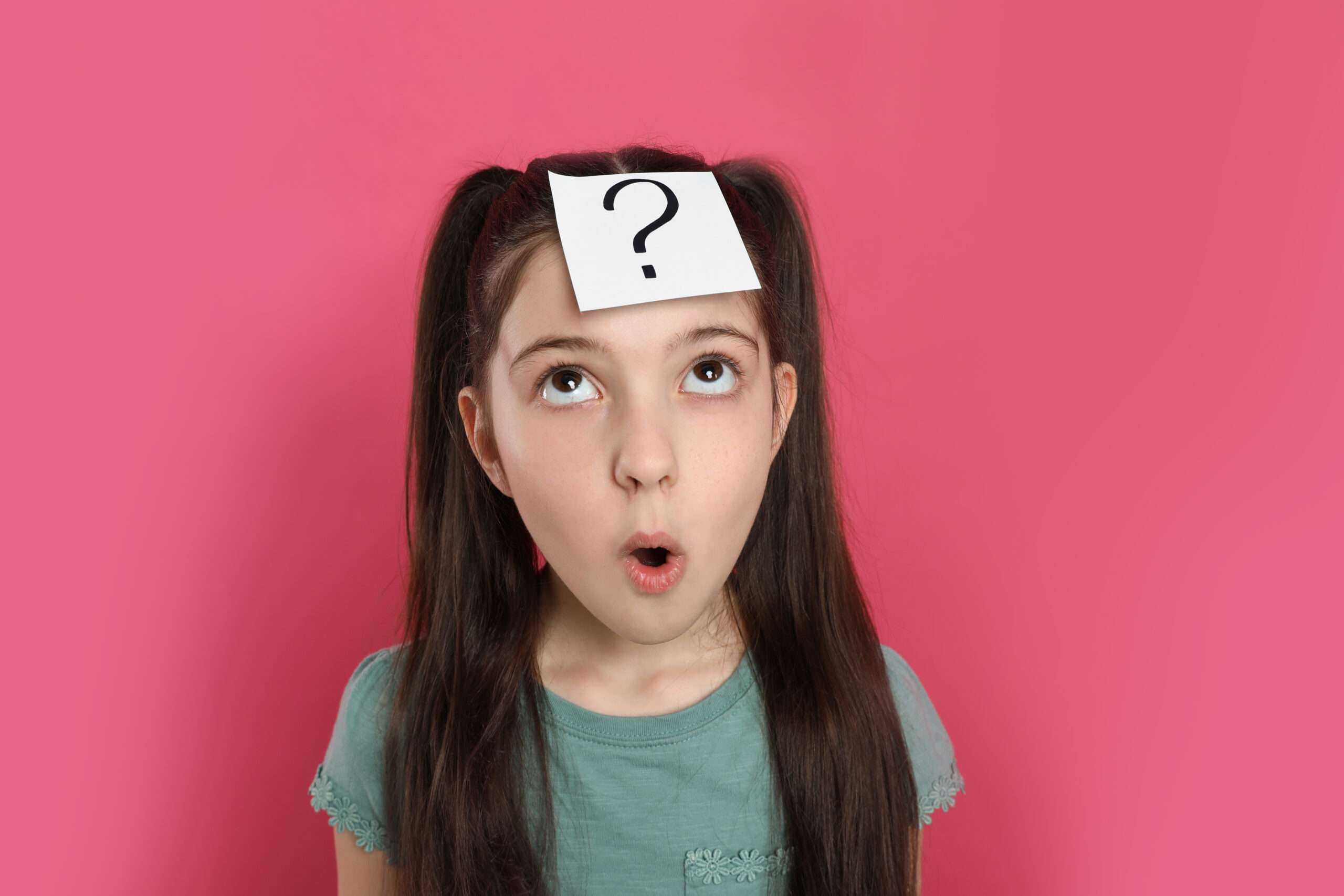 頭に疑問符を付けてスペイン語の単語当てゲームをしている若い女の子。