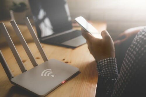 スペインで、ワイヤレス ルーターに接続されたラップトップを使用している人がいます。