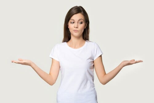 白い背景の前で手を広げ、スペインのポーズをとっている女性。