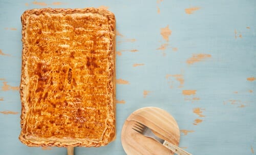 スペイン料理をイメージした青色の背景にナイフとフォークが付いたパイ。