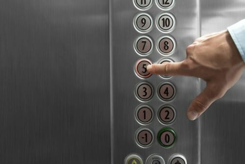 スペインでエレベーターのボタンを押している人。