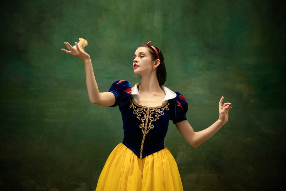 スペインの白雪姫の衣装を着た女性がクッキーを持っています。