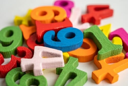 スペイン木製のカラフルな数字が白い表面に並べられています。