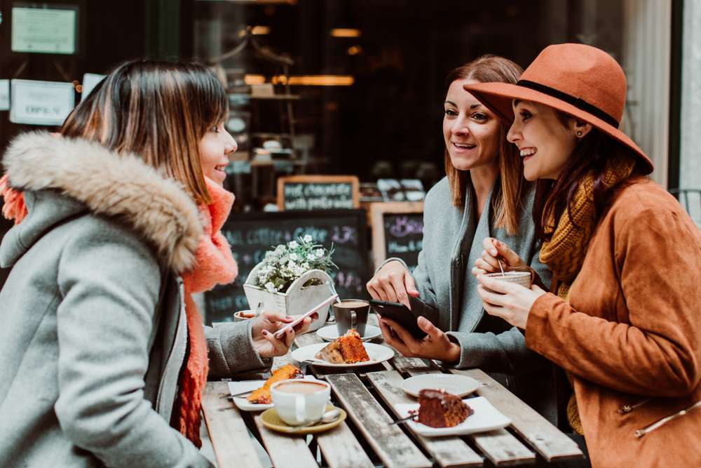 スペインのカフェのテーブルで話している 3 人の女性。