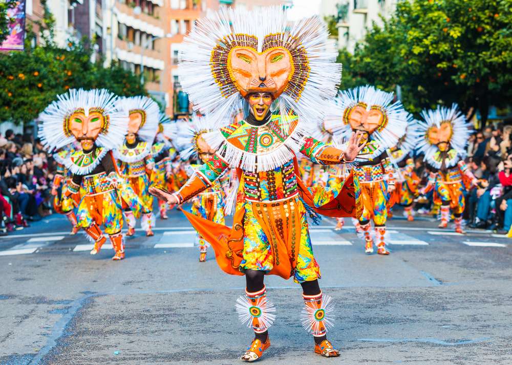 スペインの祭りやパレードでは、ライオンに似た大きな頭飾りをつけた、色鮮やかな衣装を着た人々のグループが路上でダンスを披露します。