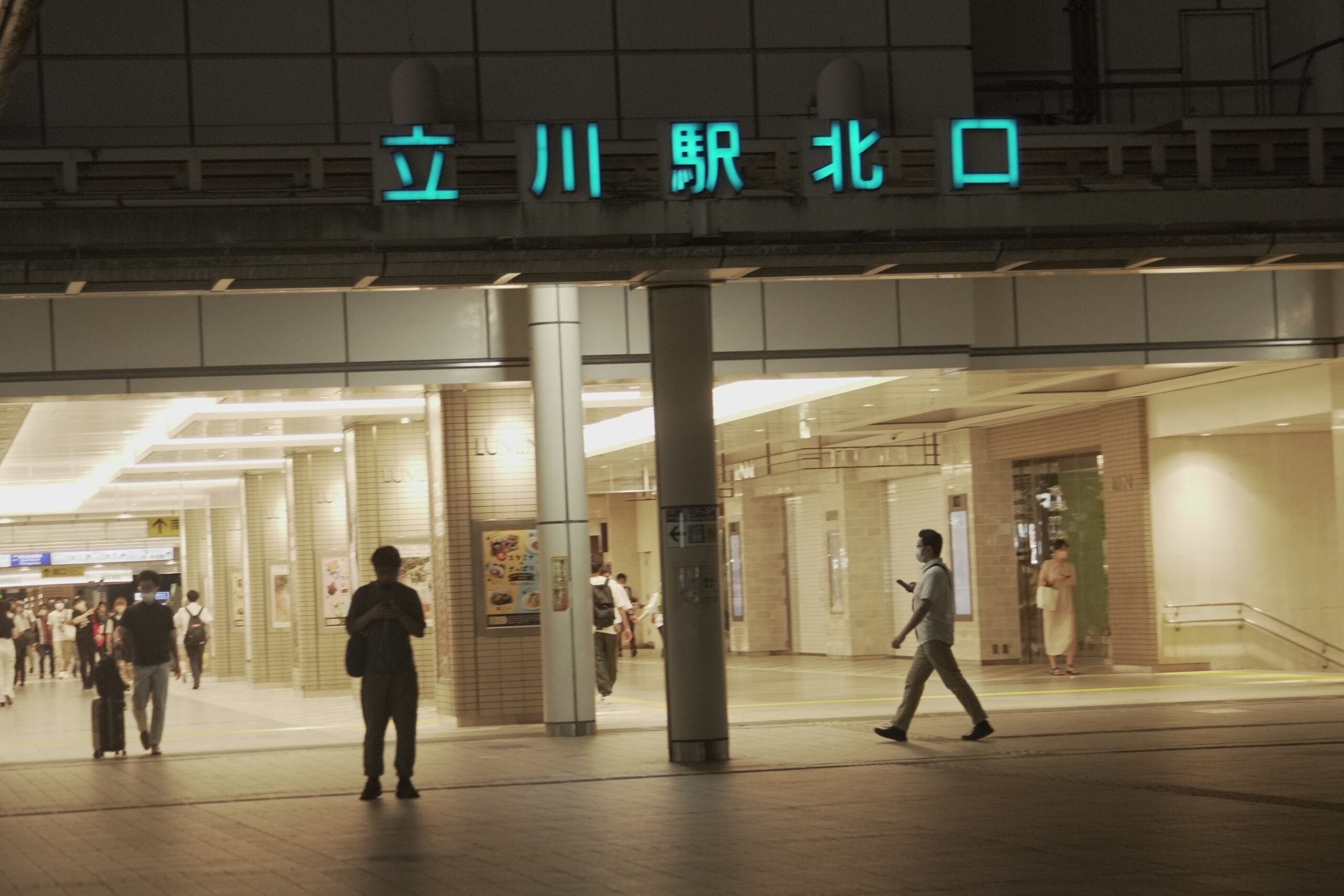 夜、立川駅北口付近を歩く人々は、電飾看板やモダンな建築デザインが活気に満ちた雰囲気を作り出しています。近くには、マンツーマンのスペイン語クラス (スペイン語教室マンツーマン) があり、学習者に言語スキルを向上させる機会を提供しています。.